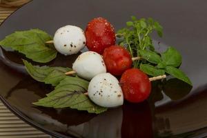 ensalada caprese en el plato y fondo de madera foto