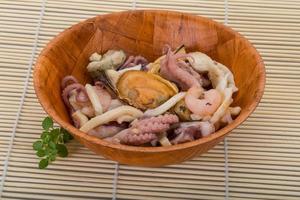 Seafood cocktail in a bowl on wooden background photo