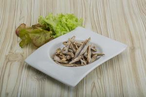 Dries anchovy in a bowl on wooden background photo