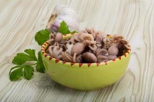 Boiled octopus in a bowl on wooden background photo