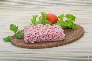 Raw minced pork meat on wooden board and wooden background photo