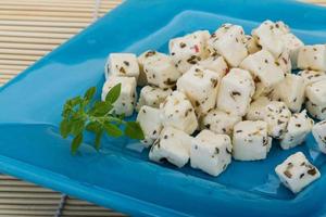 Cheese with spices and oil on the plate and wooden background photo