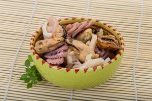 Seafood cocktail in a bowl on wooden background photo