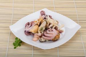 Seafood cocktail on the plate and wooden background photo