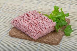 Raw minced pork meat on wooden board and wooden background photo