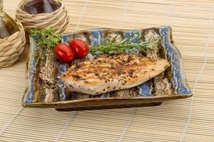 Grilled chichen breast on the plate and wooden background