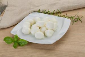 queso mozzarella en el plato y fondo de madera foto