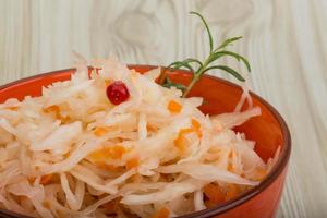 Sauerkraut in a bowl on wooden background photo