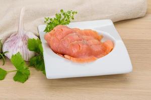 Sliced salmon in a bowl on wooden background photo