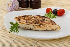 Grilled chichen breast on the plate and wooden background photo