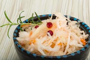 Sauerkraut in a bowl on wooden background photo