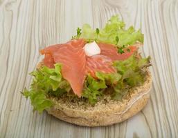 Salmon sandwich with thyme on wooden background photo