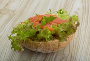 Salmon sandwich with thyme on wooden background photo