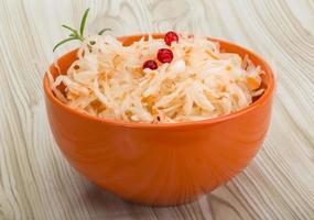 Sauerkraut in a bowl on wooden background photo