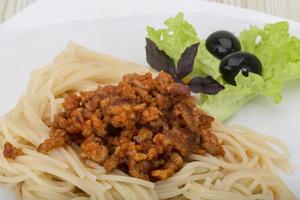Pasta Bolognese on the plate and wooden background photo