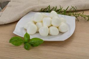 Mozzarella cheese on the plate and wooden background photo