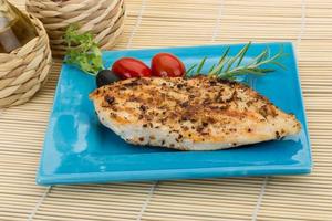 Grilled chichen breast on the plate and wooden background photo