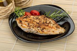 Grilled chichen breast on the plate and wooden background photo