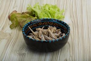 Dries anchovy in a bowl on wooden background photo