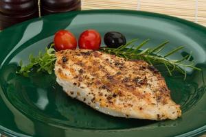 Grilled chichen breast on the plate and wooden background photo