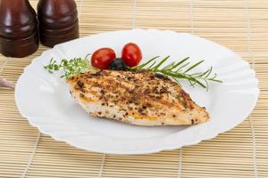 Grilled chichen breast on the plate and wooden background photo