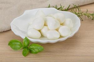 queso mozzarella en el plato y fondo de madera foto