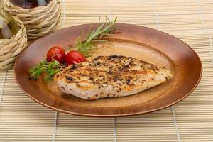 Grilled chichen breast on the plate and wooden background photo