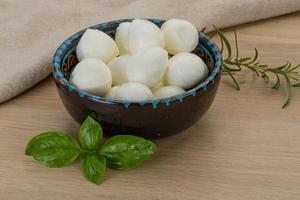 Mozzarella cheese in a bowl on wooden background photo
