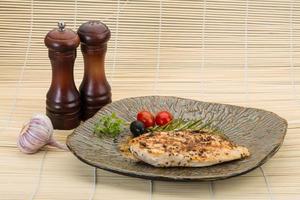 Grilled chichen breast on the plate and wooden background photo