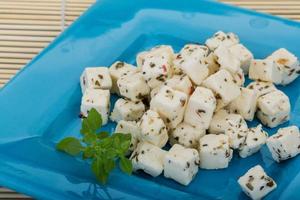 Cheese with spices and oil on the plate and wooden background photo