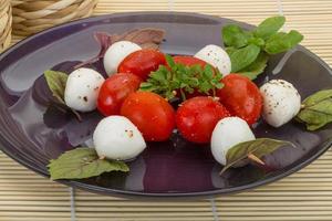 ensalada caprese en el plato y fondo de madera foto