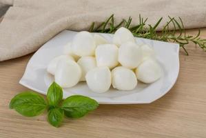 queso mozzarella en el plato y fondo de madera foto