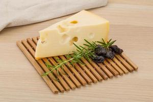 Cheese maasdam on wooden board and wooden background photo
