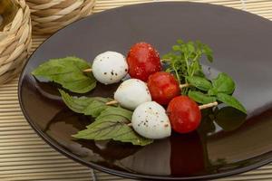 ensalada caprese en el plato y fondo de madera foto