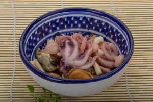 Seafood cocktail in a bowl on wooden background photo