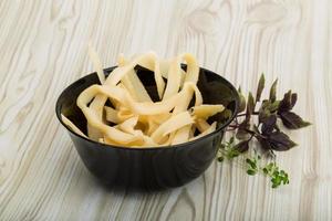 Dried squids in a bowl on wooden background photo