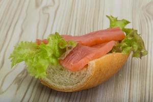 sándwich de salmón sobre fondo de madera foto