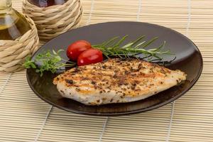 Grilled chichen breast on the plate and wooden background photo