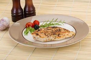 Grilled chichen breast on the plate and wooden background photo