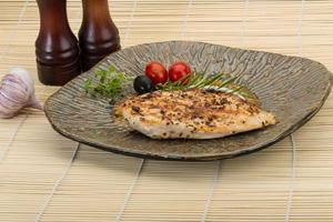 Grilled chichen breast on the plate and wooden background photo