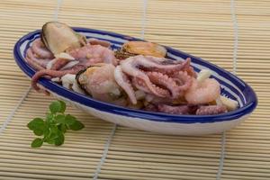 Seafood cocktail in a bowl on wooden background photo