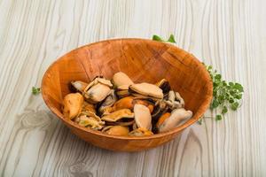 Mussels in a bowl on wooden background photo