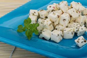 Cheese with spices and oil on the plate and wooden background photo