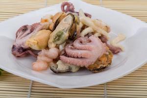 Seafood cocktail on the plate and wooden background photo