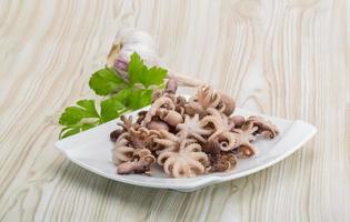 pulpo hervido en el plato y fondo de madera foto