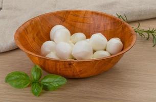 Mozzarella cheese in a bowl on wooden background photo