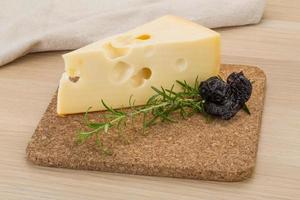 Cheese maasdam on wooden board and wooden background photo