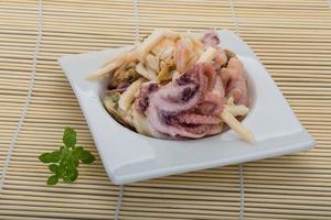 Seafood cocktail in a bowl on wooden background photo