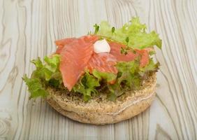 Salmon sandwich with thyme on wooden background photo