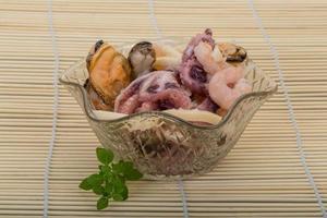 Seafood cocktail in a bowl on wooden background photo